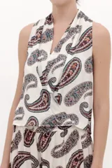 Blusa top fluida sin mangas con cuello halter y estampado paisley en tonos marrones y azules sobre base blanca.