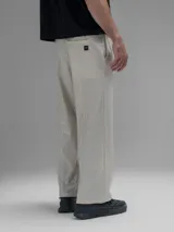 Pantalón cargo de corte oversize confeccionado en microfibra elastizada color beige. Presenta cintura elástica, bolsillos laterales y un bolsillo cargo con cierre de broche a presión. Incluye un sistema de elásticos con tancas en los tobillos para ajustar la apertura.