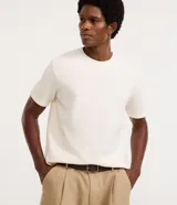 Remera de corte regular y diseño texturizado, color blanco, con cuello redondo y manga corta.