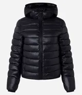 Campera puffer deportiva de mujer, confeccionada en tejido tecnológico ligero con relleno acolchado. Presenta capucha integrada, cierre frontal con cremallera y diseño de manga larga. La prenda destaca por su versatilidad, siendo capaz de transformarse en una pequeña cartera.