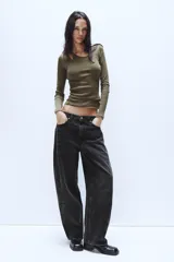 Jeans de tiro medio con diseño baggy barrel, confeccionados en denim color beige con efecto lavado. Presentan cinco bolsillos, costuras laterales torcidas y cierre frontal con cremallera y botón metálico.