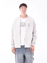 Campera gris claro de corte bomber, con cuello, puños y ruedo acanalados. Presenta cierre frontal y bolsillo en el pecho con cierre.