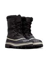 Bota Sorel modelo Caribou para hombre, diseñada para climas fríos y nieve. Presenta capellada de nobuk impermeable en color negro, parte inferior de goma vulcanizada en tono negro y blanco, cordones frontales con anillas metálicas, y cuello con forro de pelo sintético.
