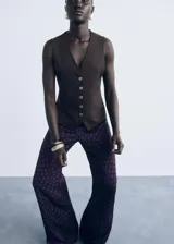 Pantalón de tiro medio con diseño flare y largo, con cierre de cremallera lateral y estampado de lunares.