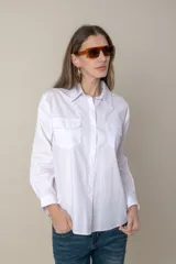 Camisa blanca de manga larga con dos bolsillos frontales con solapa.