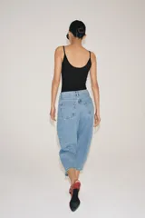 Jeans capri balloon leg de tiro medio en color celeste, con trabillas para cinto, bolsillos delanteros y traseros, y cierre frontal con botón y cremallera.