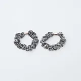 Pack de cuatro coleteros tipo scrunchie, dos en color bronce satinado y dos con estampado de piel de serpiente en tonos gris y negro. Cada uno cuenta con un detalle metálico central.