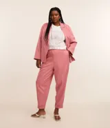 Pantalón de sastrería estilo carrot color rosado, con bolsillos laterales, cintura elastizada y botamangas con dobladillo vuelto.