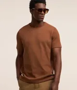 Remera de manga corta y cuello redondo, confeccionada en tejido de media malla con textura vertical. Presenta un diseño minimalista y ligero, ideal para un uso versátil y cómodo.