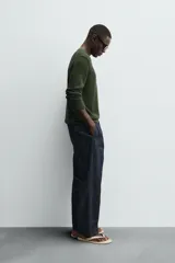 Jersey de punto color verde oliva, de corte regular fit, con cuello en V y manga larga.