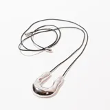 Collar con dije plateado en forma de U irregular, colgando de un cordón negro ajustable.