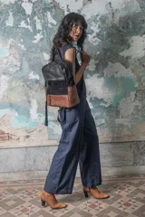 Mochila negra con parte superior de cuero liso, parte central de gamuza y parte inferior con textura símil cocodrilo.