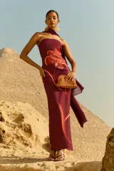 Chal de gasa color burdeos, con diseño drapeado que se extiende desde el hombro.