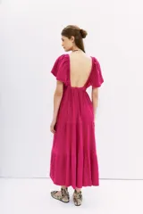 Vestido midi de color fucsia, con escote en V profundo, mangas cortas amplias y cintura elastizada. Presenta una falda con caída fluida y espalda cuadrada.