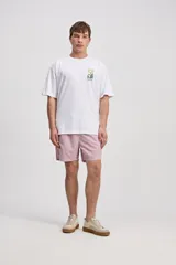 Remera oversize gris de algodón, de manga corta, con estampa en la espalda de formas botánicas abstractas y el logo de la marca.