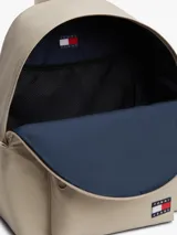 Mochila Tommy Jeans Essential Dome de tejido ripstop en color beige, con diseño curvo, compartimento principal con cierre de cremallera, bolsillo exterior frontal con cremallera, asa superior y correas ajustables y acolchadas. Incluye parche con el logo de la marca en el bolsillo frontal.