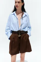 Bermuda de tiro alto color azul marino, con pinzas delanteras, bolsillos laterales y cinturón trenzado color marrón.