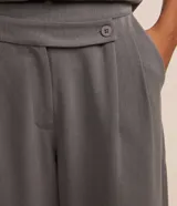 Pantalón de vestir gris de corte recto, con bolsillos laterales y traseros. Se ajusta a la cintura con cierre asimétrico de botones.