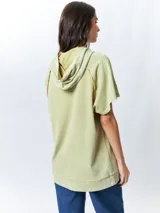 Chaleco negro lavado de algodón con capucha y gran bolsillo central. De corte oversized, holgado, suave y cómodo.