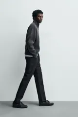 Jeans de corte slim fit en color azul oscuro, con diseño de cinco bolsillos, cierre frontal con cremallera y botón, y tejido ligeramente elástico.