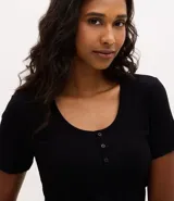 Blusa de pijama marca Lov, confeccionada en tejido rib acanalado. Presenta un diseño regular con cuello redondo, cierre frontal parcial con botones y mangas cortas.