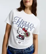 Remera de algodón color blanco, con cuello redondo, manga corta y estampado frontal de Hello Kitty con temática de tenis.