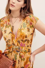 Vestido largo color mostaza con estampado paisley y floral, cuello en V, mangas cortas y cintura elastizada fruncida.