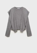 Buzo de punto fino color gris melange, con cuello redondo y diseño de mangas con solapas decorativas superpuestas. Presenta un corte recto y mangas largas con puños ajustados.