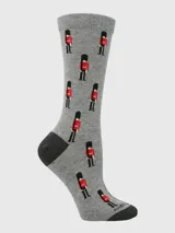 Calcetín de largo medio color gris con estampado de guardias británicos en rojo y negro. Cuenta con talón y puntera reforzados en color gris oscuro.