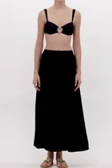 Pantalón fluido de corte ancho, color negro con sutil acabado brillante, cintura elástica y diseño holgado.
