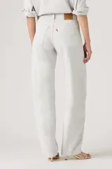 Pantalón de jean estilo baggy con corte barrel, tiro alto y pierna ancha. Presenta un tono gris claro lavado, con costuras reforzadas y diseño de cinco bolsillos.