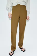 Pantalón de tiro alto con corte recto, cierre frontal con cremallera y botones decorativos en el bajo.