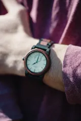 Reloj Chenaut Perle d’Ébène con caja de madera de sándalo rojo, esfera blanca perlada con manecillas azules y malla de madera de ébano.