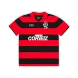 Camiseta de punto de algodón con diseño de rayas horizontales en rojo y negro. Presenta cuello polo, mangas cortas y bordados en el pecho.