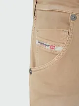 Jean tipo jogg de Diesel, modelo Krooley, en color beige con efecto desgastado. Presenta cintura elástica con cordón de ajuste negro, cierre frontal y diseño de cinco bolsillos.