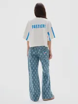 Pantalón de jean de tiro medio, corte flare, confeccionado en algodón y con estampado a cuadros en tonos azules.