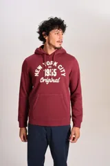 Hoodie bordó con capucha y cordones ajustables, presenta un estampado frontal con texto en color crema y bolsillo tipo canguro.