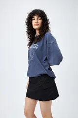 Minifalda color beige estilo cargo, de tiro bajo y corte recto, con bolsillos laterales.