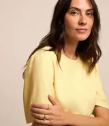 Blusa de viscolino color amarillo pálido, con cuello redondo y mangas cortas abullonadas.