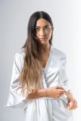 Bata corta color blanco de satén elastizado, con mangas tres cuartos con volados y lazo para atar en la cintura.