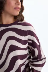 Buzo de punto con estampado de ondas en color bordó y beige, cuello redondo y mangas largas.