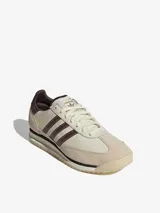 Zapatillas Adidas modelo SL 72, con diseño retro en tonos crema y marrón. Presentan una base de cuero con superposiciones de gamuza, las icónicas tres tiras laterales en marrón y una mediasuela de EVA con suela de caucho dentada.