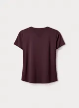 Camiseta deportiva de manga corta en color bordó, con diseño de cuello redondo y paneles laterales con perforaciones para mayor ventilación. Presenta un pequeño logo reflectante en la parte inferior.