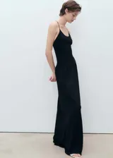 Vestido largo de punto fino color negro, con diseño recto, cuello escotado y tirantes finos que se cruzan en la espalda.
