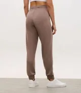 Pantalón tipo jogger de mujer, confeccionado en tejido modal con mezcla de poliéster y elastano. Presenta cintura elástica con lazo de ajuste, bolsillos laterales y puños elásticos en el ruedo.