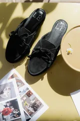 Mules de gamuza color tostado con diseño de zapato náutico, con cordones frontales y plantilla con logo estampado.