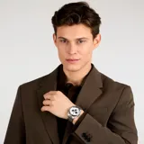 Reloj Maserati para hombre, modelo Velocita R8873652007, con caja de acero inoxidable plateada de 43mm, esfera blanca con detalles en azul y brazalete de acero inoxidable plateado. Cuenta con movimiento de cuarzo Miyota JS25, cronógrafo, subesferas, fecha, taquímetro y cristal mineral reforzado. Resistente al agua hasta 100 metros.