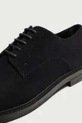 Zapato de cordones tipo derby para hombre, fabricado en piel con acabado en serraje de color azul marino, con horma redonda y suela a contraste.
