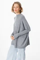 Sweater crudo de punto con cuello alto y mangas largas con puños ajustados.