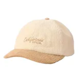 Gorro tipo gorra de visera curva Rip Curl confeccionado en pana de color beige claro con la visera en tono tostado. Cuenta con un bordado frontal con la inscripción "California Rip Curl" en tono marrón.